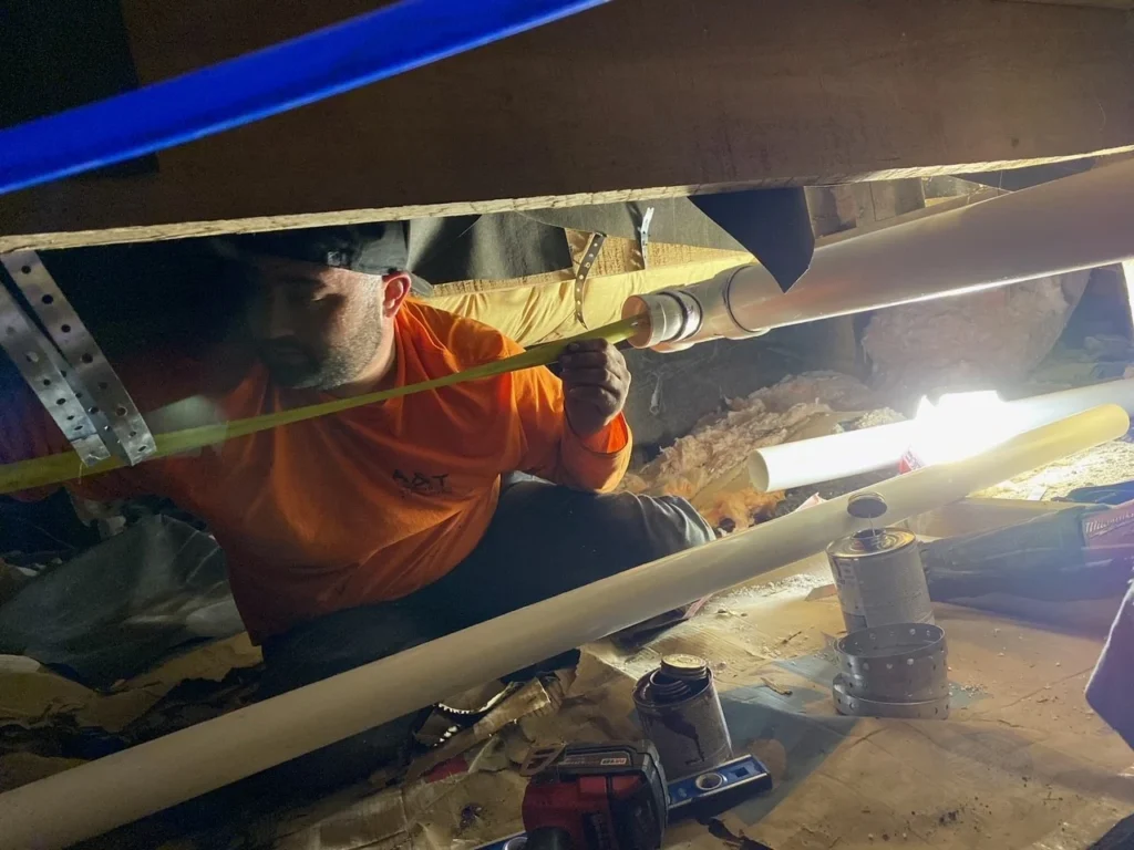 Section of corroded steel pipe being cut out and replaced with copper